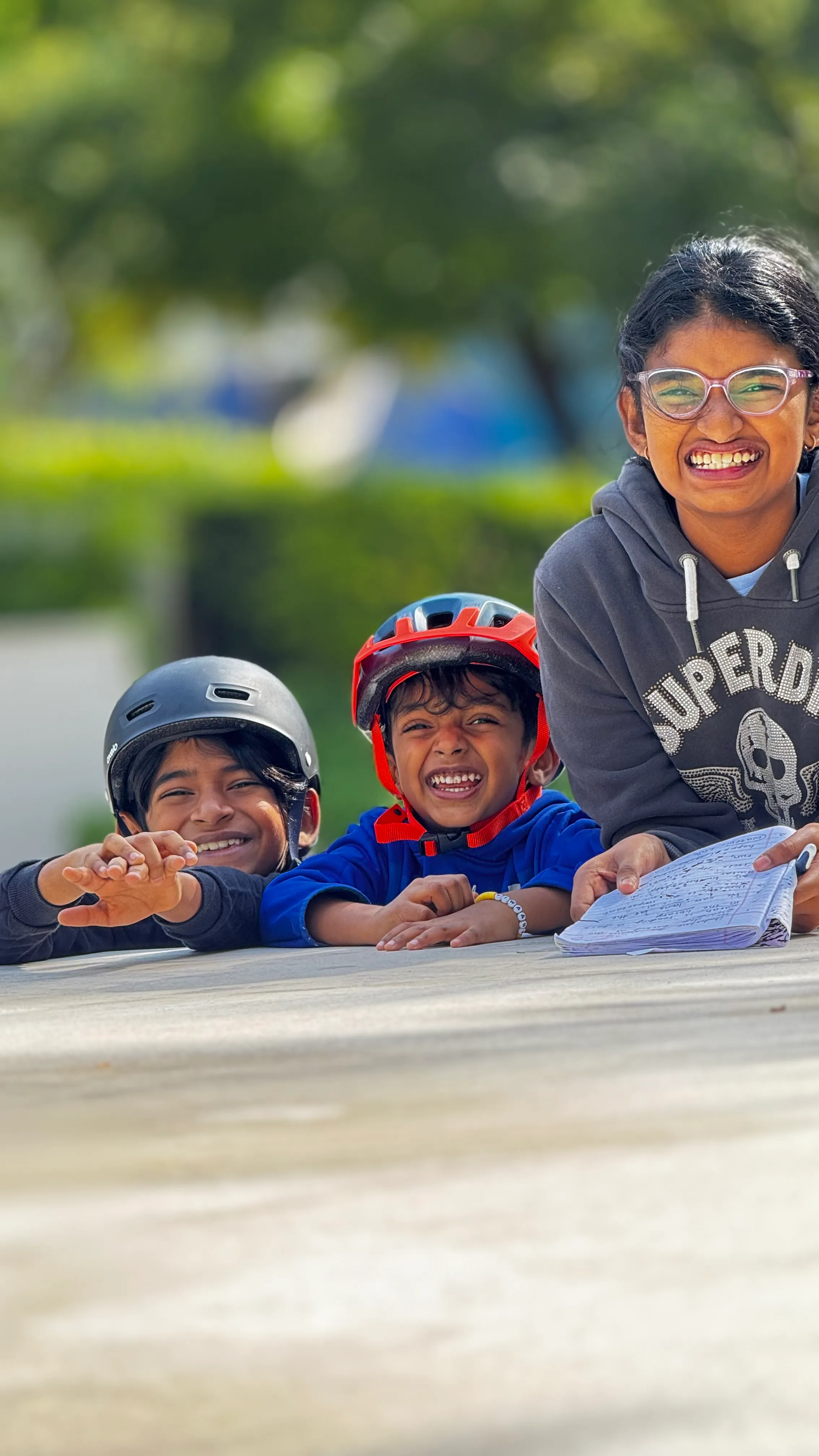 Children smiling with helmets while learning and playing together.