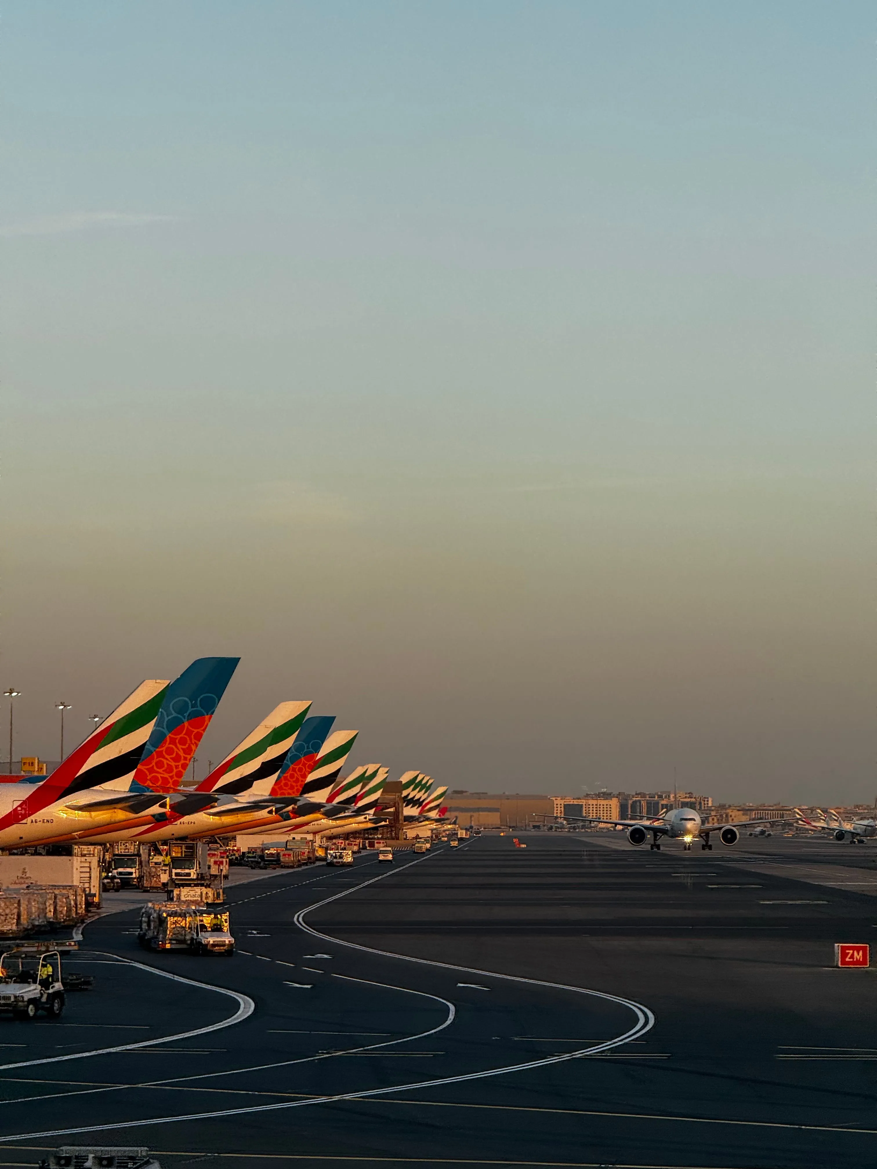 A line of aircraft at golden hour, ready to carry work across the world.